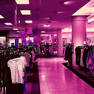 heavily pink-filtered image of large department store with racks of clothing
