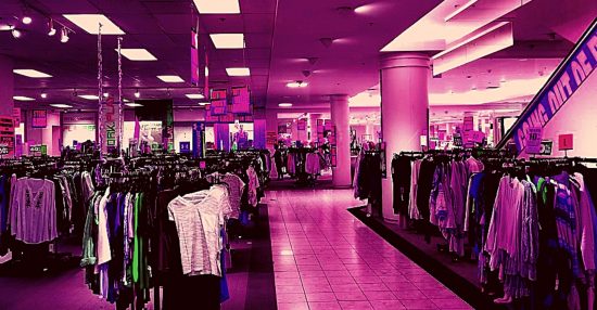 heavily pink-filtered image of large department store with racks of clothing